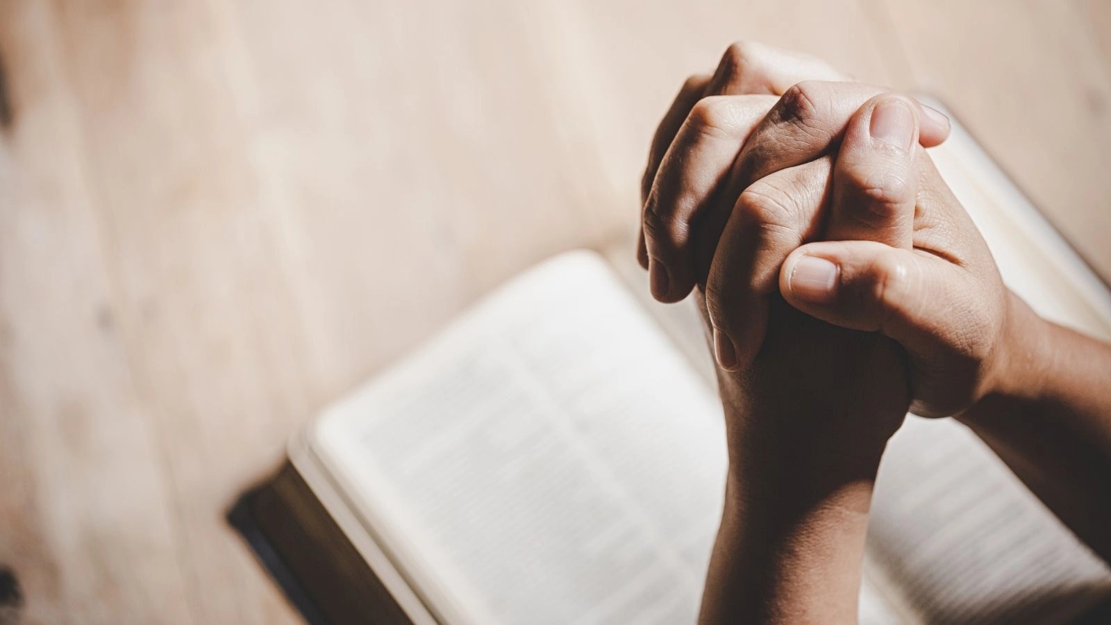 picture of folded hands over a bible